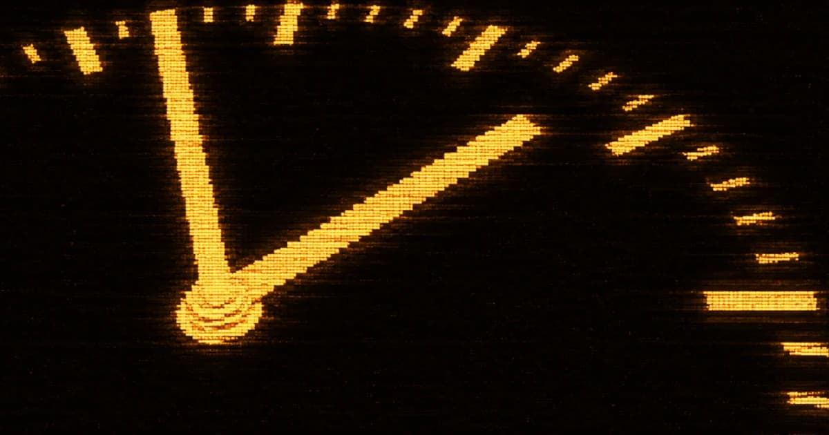 Close-up of a partially cropped clock face with two hands extending from a central pivot.
