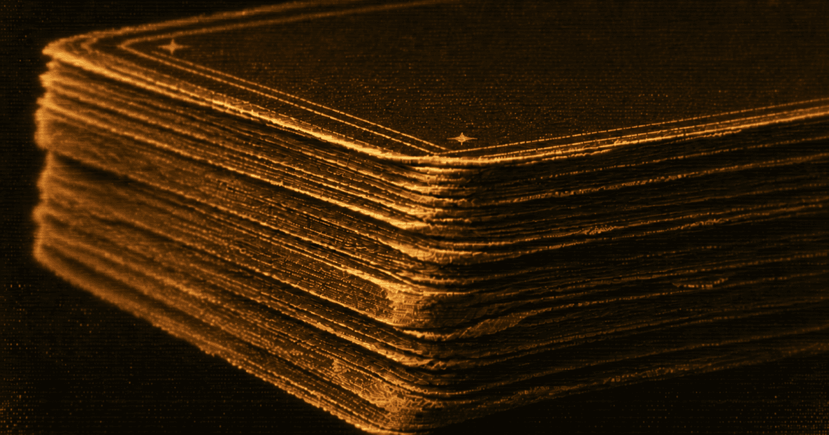 Close-up of a worn tarot deck with frayed layered card edges.