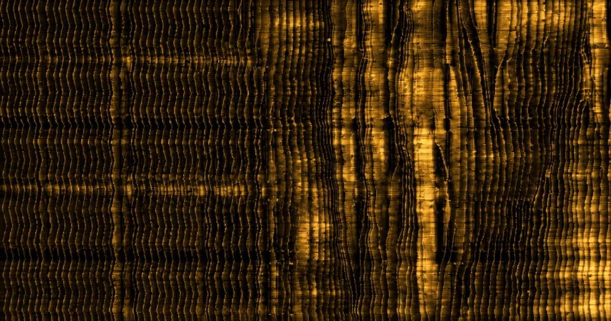 Close-up of repeated corrugated layers, with several sections bent, compressed, and irregular among otherwise uniform vertical folds.