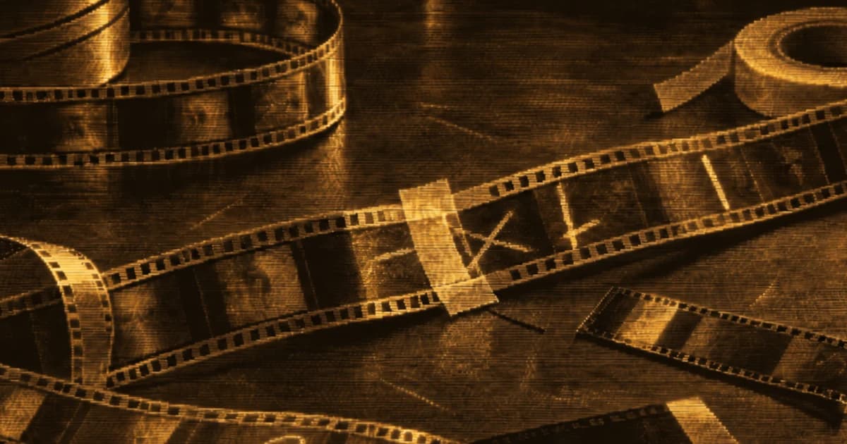 Film editing workbench with loose strips of motion-picture film, taped splices, grease-pencil marks, a roll of editing tape, and film canisters.